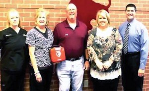 AED DONATION - Susanne Boston (left) and Robert Stapp (far right) of North Texas Sport and Spine present a new automated external defibrillator (AED) to Bridgeport High School recently as school nurse Linda Green, athletic trainer Billy Newsom and Principal Jaime Sturdivant accept for the school. Submitted photo
