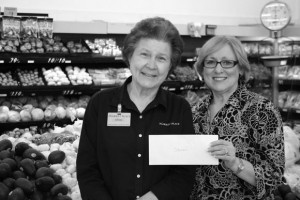 HELPING THE HUNGRY - Market Place employee Odessa Presson (left) is presented with a cash prize for outstanding contribution to the fund-raising effort by co-owner Margie Shelton.