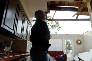 SEEING THROUGH - Rex RIchie, interim police chief at Runaway Bay, stands in the middle of an exposed condominium on Runaway Bay Drive. Wind peeled the roof off the building in Sunday's storms. Messenger photo by Joe Duty