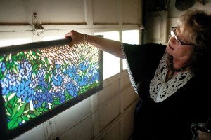 BLUEBONNETS - Totty shows one of her larger mosaic pieces. She lined up small pieces of glass to create a bluebonnet scene. Messenger photo by Jimmy Alford