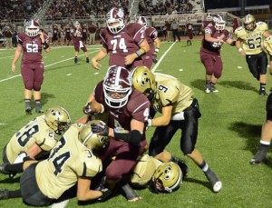 GANG TACKLE - Alvord's Ty Silvey (9), Brandon Aeling (28) and Shane McKinney (34) combine to bring down a Bowie runner. Messenger photo by Mack Thweatt