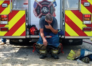 GETTING RELIEF - Slidell/Greenwood firefighter Rodney Yard tries to catch his breath after being overcome by the heat and smoke while fighting Thursday's blaze. Messenger photo by Joe Duty