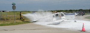 Decatur firefighters spray down fuel leaking from the downed plane with foam. Photo by Joe Duty.