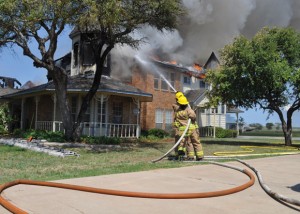 WRECKED RENOVATION - Firefighters from six departments battled tirelessly for almost seven hours in 99-degree heat as a 3,500-square-foot home burned on the prairie. The owner was in the process of renovating the 26-year-old house. Messenger photo by Brandon Evans