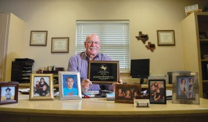STATE'S BEST - Bill Austin, chief juvenile probation officer of Wise County, was recognized with the Juvenile Justice Association of Texas Outstanding Achievement in Probation award at an annual convention this week. Austin and his wife, Kristi, have three sons - Billy Austin, Travis Austin and Rusty Thomas - and six grandchildren ranging in age from 4 to 14 (in the pictures on the desk). "We are nuts about our grandkids," Austin said. Messenger photo by Joe Duty