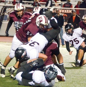 IN THE TRENCHES - Bull defenders Hagen Davis (54) and Jessie Smith (8) up-end Argyle runningback Terry Moore in Friday night's playoff game in Flower Mound. Messenger photo by Mack Thweatt
