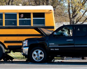 PEEKING OUT - A Chisholm Trail Middle School student surveys the smashed truck that ran into the rear of the school bus. Messenger photo by Jimmy Alford