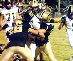 SANDWICHED - Alvord's Brandon Aeling and Shane McKinney team up to crunch a Henrietta runner in the 12-10 Bulldog win Friday. Messenger photo by Mack Thweatt