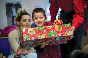 ALL SMILES - Rosendo Fernandez Jr. of Decatur receives a box of gifts donated by local 4-H members and their families with a grin. The gift boxes contained a set of clothes, shoes, toiletries and toys donated by 4-H members and their families. Messenger photo by Joe Duty