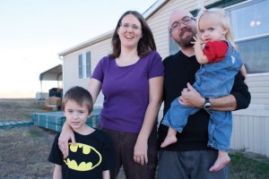 TOGETHER - (From left) Xander, Melanie Doug,  and Sydney Snitker pose for an impromptu family portrait in front of their current home near Decatur. Messenger photo by Jimmy Alford
