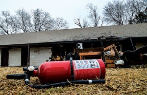 AFTERMATH - An empty fire extinguisher sits on the lawn outside the Eighter from Decatur apartments. Fire ravaged one of the buildings at the complex Sunday night, leaving three units gutted, one with heavy damage and three others with heavy smoke damage, according to Decatur Fire Chief Mike Richardson. Messenger photo by Joe Duty
