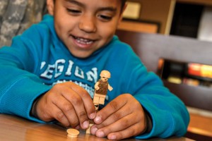 FIGHTING IRON MAN - Using a toy soldier named after his favorite uncle, Aiden Saenz explains how his Bubba fights Iron Man. "He gets on big cars and shoots villains. And they blow up," he said. His uncle, Jose Rodriguez, is a diesel mechanic in the U.S. Army. Messenger photo by Joe Duty
