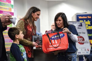 GOODY BAG - Eva Royer, KLTY senior account executive, presents Gwen Hilliard with her bag of prizes during Monday's presentation in her classroom at Northwest High School. Looking on in the background is Hilliard's father, Arnold Jochim. Messenger photo by Joe Duty