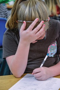 GROUPED TOGETHER - Teachers and administrators say CSCOPE stresses more group work and lessons that require higher-level thinking than past curriculums. Boyd fifth-grader Lindsay Carroll scratches her head while solving math problems. Messenger photo by Joe Duty