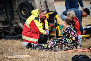TENDING TO TRAGEDY - Wise County medic Randall Preuninger tends to Tina Gillium, 21, of Colorado Springs, Colo., injured in Friday morning's wreck where six people were ejected from the wrecked van. Messenger photo by Joe Duty
