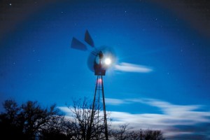 BLOWING IN THE WIND - A windmill at TADRA Point spins furiously in the heavy, early morning wind. Behind, the full moon shines brightly, illuminating the clouds. Messenger photo by Jimmy Alford