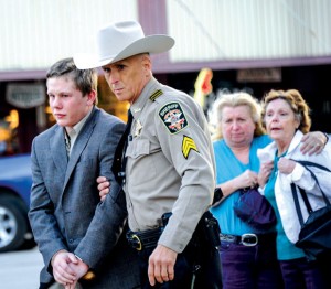 LONG WALK - Distraught family members of Danny Nalley watch as Sgt. Cavin Riggs with the Wise County Sheriff's Office leads the 19-year-old from the courthouse in Decatur Thursday evening. He had just been sentenced to two years in state jail for criminally negligent homicide. Messenger photo by Joe Duty