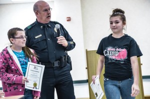 ONE GOOD TURN - Boyd Police Chief Greg Arrington commends sisters Kearstin Cruz, 11, and Celeste Cruz, 13, for their model behavior at a function for the girls at Boyd Middle School last Friday. The sisters found a wallet in a parking containing almost $1,400 in cash and immediately turned it over to the proper authorities. Messenger photo by Joe Duty
