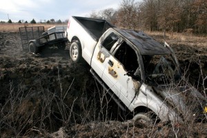 SUDDEN STOP - A pickup pulling a stolen trailer, driven by Shannon Hood, took a nose-dive into a ravine Sunday. The pickup caught fire, which spread to the grass and two patrol vehicles. Messenger photo by Joe Duty