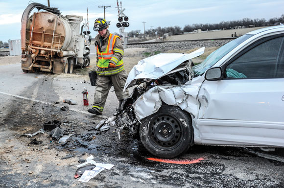 WRECK SCENE - A firefighter surveys the damage following an accident at Texas 114 and County Road 3241 near Paradise Monday morning. Toby Baker, who was driving the white Hyundai Elantra, later died at Wise Regional Health System in Decatur. Messenger photo by Joe Duty