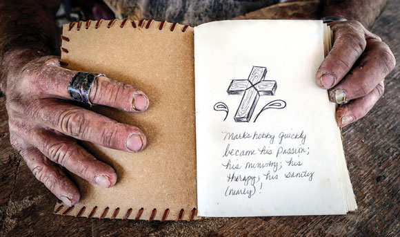 GOOD BOOK - Mark Irland tries to live his life by the teachings of the Bible. He's turned his own personal tragedy into a form of ministry. This book holds the names of people for whom he made crosses. But he made so many, and many times in complete anonymity, that he lost count. He figures to have constructed about 900 crosses in the past three years. Messenger photo by Joe Duty