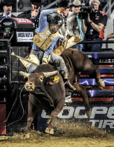 RIDING TO FOURTH - Decatur bull rider Mike Lee maintains a tight grip atop in bull-riding action Saturday at the Iron Cowboy IV at Cowboys Stadium in Arlington. Lee advanced to the semifinals and garnered enough points to climb to fourth place in the overall Built Ford Tough Series standings before being ousted by L.J. Jenkins. Messenger photo by Joe Duty