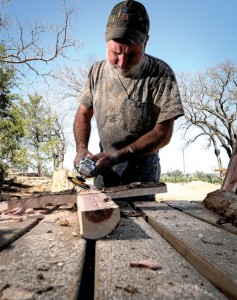 SCULPTING CROSSES - "God did the hard work. He grew them. I only shaped them into a cross," Mark Irland said as he transforms a cedar tree into a cross. Messenger photo by Joe Duty