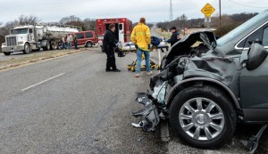 SERIOUS ACCIDENT - Emergency responders wheel Edwina Norris of North Richland Hills to an ambulance Friday morning after a four-vehicle accident at the intersection of Farm Road 920 and Texas 199 south of Boonsville. She was the driver of the Buick Enclave pictured in the foreground. Messenger photo by Joe Duty