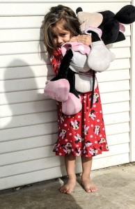 OUT OF THE DARKNESS - Valentina Barrios, 2, stands on the front porch of her Decatur home, clutching a Minnie Mouse doll shortly after waking up one day last week. Valentina's mother, Claudia Bermudez, said much of her own life has been spent living in the shadows as an undocumented immigran. Messenger photo by Joe Duty