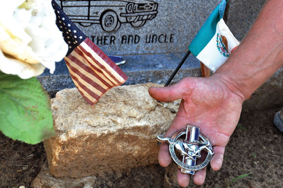 NO MEMENTO - The ornament from a Ford Mustang rests with other items at the grave of Omar Carrillo. Messenger photo by Brandon Evans