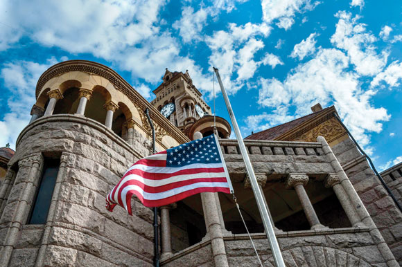 A LEADER LOST - The flag at the Wise County Courthouse flies at half-staff Friday in honor of County Judge Bill McElhaney. The 67-year-old collapsed and died in a commissioners meeting Monday and was honored at a memorial service Thursday at the Decatur Civic Center. Messenger photo by Joe Duty