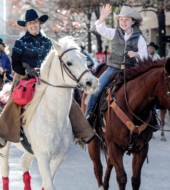 ALL SMILES - Candace Arnette of Decatur and a young rider smile and wave to the crowd during Saturday's stock show parade in Fort Worth. Messenger photo by Joe Duty