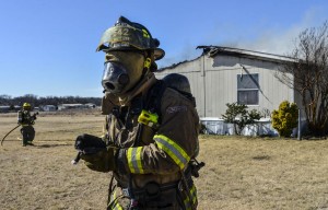 Decatur firefighter Armando Fernandez rescues a one-week-old puppy from a burning home Wednesday morning. Photo by Joe Duty.